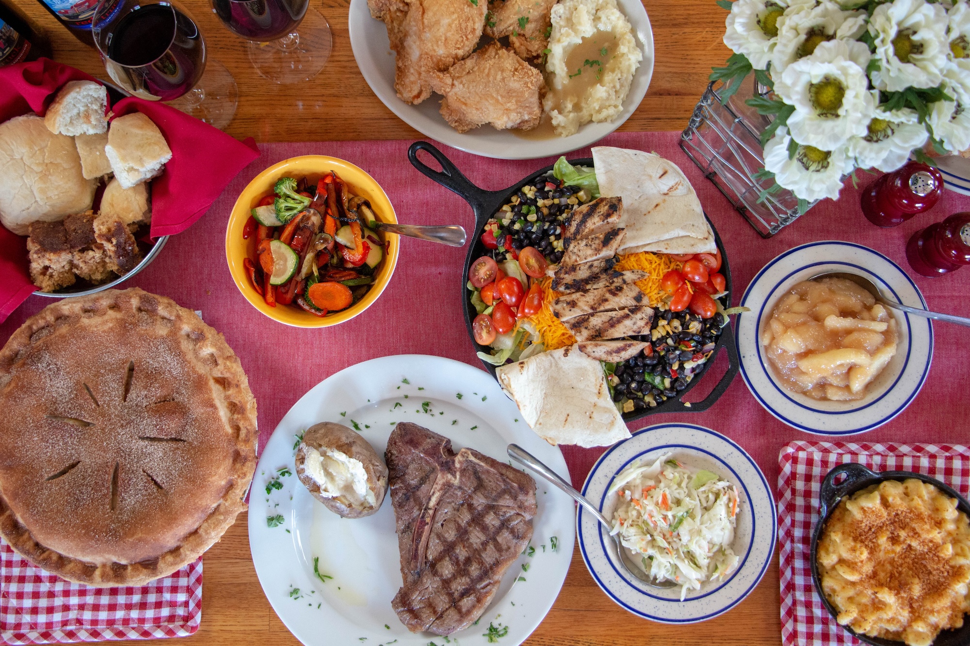 table spread with lots of food, chicken, brisket, potatoes, bread, and pie at Machine Shed