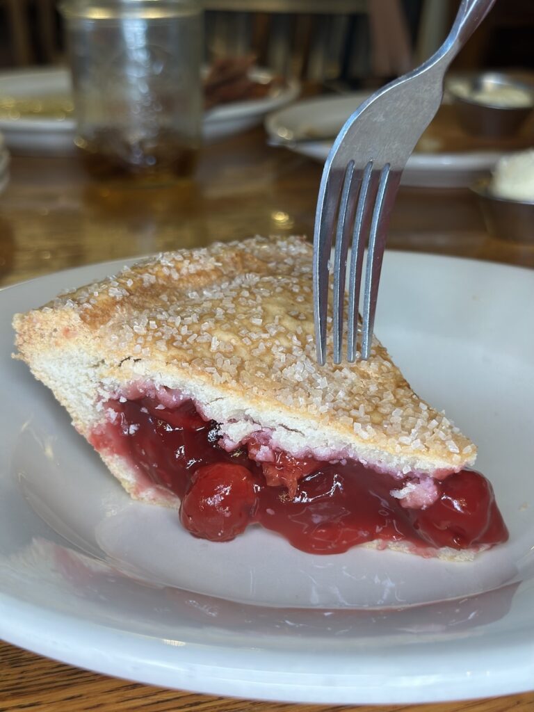 Machine Shed Cherry pie with a fork about to take a piece out to eat