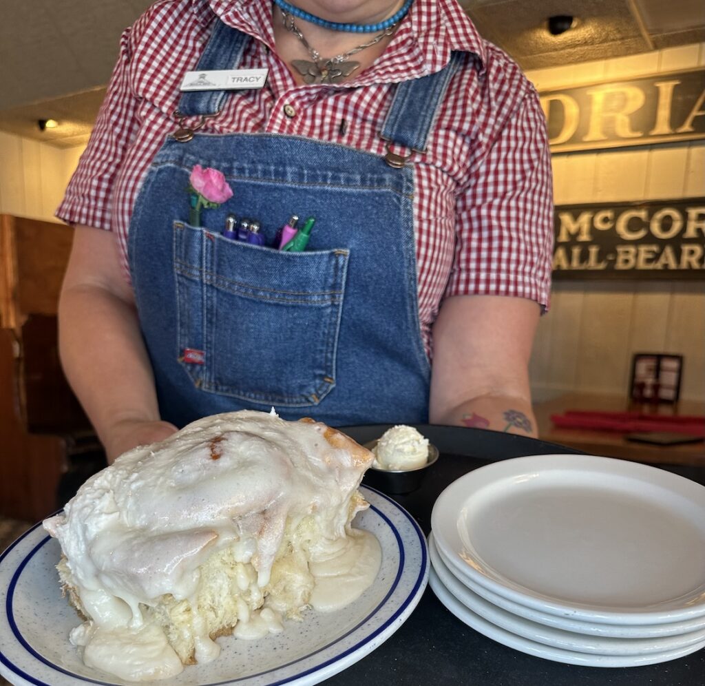 Machine Shed waitress holding a tray with a delicious Cinnamon Roll on it